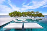 Adjacent to Ledge Lounger seating are concrete tables for intra-pool entertaining.  Each table features a custom finish created specifically for the Nirvana outdoor space. Precast was developed by Elite Cast Stone. Original outdoor living design by Ryan Hughes Design Build.