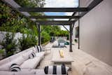 The design and durability of the sectional sofa from the Vertice Collection from Castelle provides a perfect gathering and lounging area adjacent to the gas fire pit.  The black and white theme continues on the frames and the striped pillows as well as the custom designed pergola by Ryan Hughes Design Build.    Images by Jimi Smith Photography.  