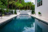 The length of the slender modern pool culminates with a spill over spa and tiled water wall. 