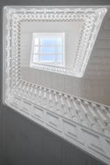 The stairway at 55 Monterrey winds around a central skylight. Restored woodwork and an all-white color scheme add a modern touch to the restoration.