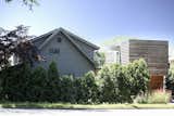 The house occupies a corner lot; both structures are visible from the side street. While evergreens provide privacy in front of the existing house, and the addition has no street-facing windows, the glassed in walkway is highly visible. 