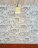 Playful wallpaper and a glowing reading light make the bunk room bench the perfect place for bedtime stories.