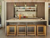 The kitchen features luxury integrated appliances from Wolf, Thermador and Bosch integrated into American blue walnut cabinets from Henrybuilt. The open island provides an oversized surface for guests to use and congregate.