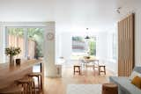 Dining Room, Chair, Ceiling Lighting, Bench, Table, Light Hardwood Floor, and Pendant Lighting The Living Space: Custom kitchen island and sliding doors were designed to reflect the family's Asian American background.  Photos