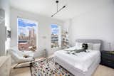 Bedroom, Ceiling Lighting, Bed, Night Stands, Shelves, Lamps, Dresser, Light Hardwood Floor, and Chair Journey past the powder room, farther down the hallway to the private sleeping quarters. 
  Photo 9 of 11 in Exquisite Dumbo Penthouse in Award Winning Condo by Halstead Real Estate