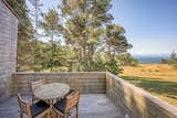 View from outdoor ocean facing deck - trees, open meadow and broad blue ocean
