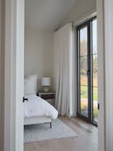 he guest bedroom exudes calm and relaxation, with a serene view from the bed. Soft natural light fills the room, creating a tranquil atmosphere perfect for unwinding and escaping into the surrounding landscape.