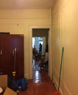 Before: A middle room connecting the living room and bedroom previously had a "saloon-style" door that was too short, and a cheap, deep-red freestanding wardrobe.  Photo 6 of 11 in Rental Revamp: An Architect Couple Reimagine a Dated Queens Apartment for Just $5K