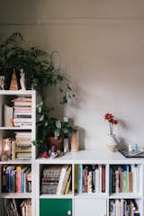 Bookshelves in the living room hold an array of found and meaningful objects, including floral tins that hold the ashes of her past dogs' ashes.