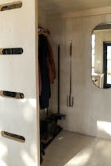 A small open closet behind the ladder wall hides coats, boots, and fishing gear.