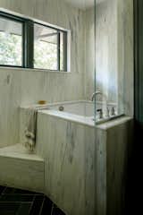After: The marble-clad primary bath evokes Zeke's childhood. "I grew up in a house that had been owned by a prizefighter, and I distinctly remember the shower being slabs of marble, floor-to-ceiling,