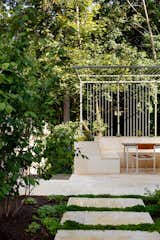 Landscape studio Moody Graham collaborated on the garden design, planting mostly edibles and a riot of flowers. The steel trellis crowns the built-in limestone bench and lavender-filled planters.