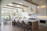 Elegant stools along the kitchen island add a touch of style.