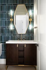 Gold-toned sconces and fixtures add glamor to the powder room.