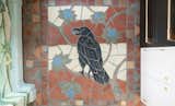 A custom crow mural in tile adds character to the kitchen floor