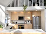Clean, sharp lines and custom hand pulls define the modern, minimal kitchen.
