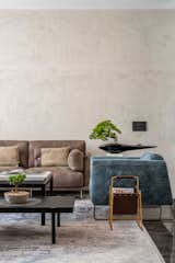 The Living room is very subtle and dull with its plain texture wall and beige sofa bringing out the flooring. The Tv unit is amazingly made of white stone with its essence of zig zag play.