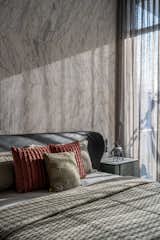Moving forward to the center room, the eye catchy white marble used in the bed back containing tints of grey veins with the interplay of brass and green color palette is what makes it silent yet powerful. As it was said earlier exploring material is what we were looking for. So giving a touch embossed lines in a repeatedly manner really breaks the plain surface of stone making it more sluggish.