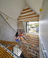 Tower House is a family residence in Victoria, Australia, whose playful plan includes an upper-level hanging net space for reading and relaxing.