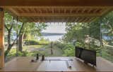 This enchanting cabin features an expansive 10-foot-wide insulated panel of glass which frames a panoramic view of the water from the workstation. The desk and cabinets are by Korben Mathis Woodworking; the desk lamp is from TaoTronics.  Photo 5 of 11 in 5 Undeniably Cool Projects Built by Designers and Their Dads