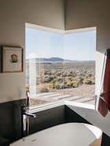 The master bathroom features one of two corner windows in the house. Lois adds that "at night, when I take a bath, I can see the moon and the stars."  Photo 7 of 11 in 5 Undeniably Cool Projects Built by Designers and Their Dads