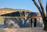 The home is located as close to the edge of the site as possible to provide views of the valley and Mount Diablo beyond. The owners’ “sharn” (part shop, part barn) is located behind the home.  Photo 3 of 11 in A Chunk of Volcanic Stone Inspires a Rock-Solid Sonoma Home