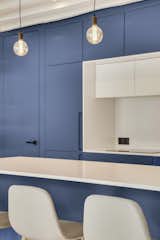 Blue and white custom made kitchen with invisible door and pendant lightings 