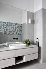 The en-suite bathroom features a palette of soft blues, grays, and whites. The geometric tiles are Deco Dusty Blu from the Spritz range by Perini.