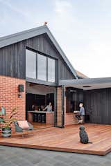 The external brick walls are part of the 1990 addition. The upper part had been rendered in acrylic and painted butter yellow. This was removed and the section was re-clad with a charred solid timber shiplap cladding. An enormous double-height window floods the living space with natural light.