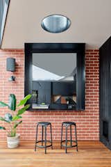 A black-framed servery window connects the kitchen to the covered deck, enabling a relaxed indoor/outdoor style of living.
