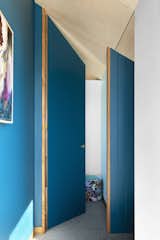 The door leading to one of the children's bedrooms on the upper level. The addition extends completely into the angled roof space to create a sense of volume.