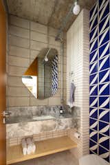 The blue and white feature tiles in the bathroom were designed by renowned local architect Éolo Maia and were gifted to the couple by a friend. "We were very happy because we admire Éolo Maia a lot," says Franchini. The bathroom counter is made from Bahia Calacatta marble.