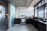 The kitchen features slightly industrial finishes—including concrete, glass and ceramic subway tiles—that are easy to clean and reflect natural light into the space.