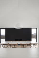 Painted steel panels frame the fireplace in the dining room and make the structure seemingly disappear, leaving only the fire visible. These steel panels also mirror the horizontal form and height of the kitchen wall it is facing. 