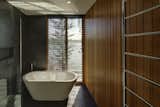The bathrooms are dark-tiled with timber-lined walls to create a sense of intimacy and privacy.
