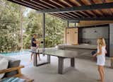 The outdoor dining table playfully converts to a ping pong table. The concrete kitchen island and dining table have been designed to be robust and low maintenance.