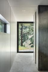 A slot window in the lower level hallway frames views of the tree-laden site. Pocket doors—which completely disappear into the walls—create an open flow of space.