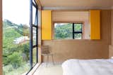 The internal bedroom windows look out over the void in the living room. The yellow shutters can be closed for privacy.