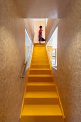 The yellow-painted stair is crafted from Kowhai, a dense and durable native timber.