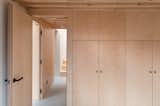 The birch plywood panelling was made off-site by the manufacturer and assembled by the builders on-site. The visual continuity of the single material makes the restricted-height storage areas appear full-height.