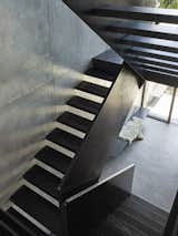 The stair features a steel balustrade and floating timber treads.