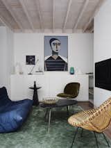 The casual living room on the ground floor features a vintage cane chair, a Togo sofa by Michel Ducaroy for Ligne Roset, and a portrait titled Matriarch by contemporary Danish artist Henrik Godsk.