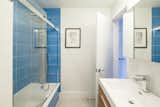 The downstairs bathroom features blue tiles. As the color orange is used on the main living floor, the color blue is found throughout the basement level. "It has something to do with the nearby bay and that by going down you are taking a journey under the water," explains Edgar.