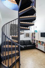 A spiral stair at the center of the living space leads downstairs to the lower "basement" level. The small spiral stair was the only solution for code-compliant vertical circulation in a house with such a small footprint. The alternative would have involved building a "saddlebag" onto the side of the house to create a traditional stair run, which would have exceeded the budget.&nbsp;