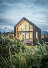 The home is defined by a simple, gabled form clad in asphalt shingles and larch weatherboards. Thanks to a combination of passive house measures and structural insulated panels, virtually no additional energy is required to maintain a consistent level of thermal comfort against the backdrop of the unforgiving New Zealand alpine climate.