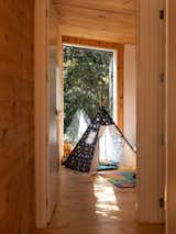 There are two bedrooms on the ground floor—one for the couple’s young son and another guest bedroom.&nbsp; The large window in this bedroom frames green views, creating an oasis within the urban context.