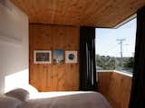 The master bedroom is on the second story. It’s a private space for Craig and his wife that also incorporates a study, an en suite bath, and a walk-in wardrobe. Timber cladding gives the home’s interior a cozy feel.