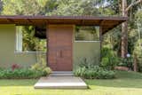 A view of the studio’s timber door. The clients planted the garden themselves using native plants. "It’s planted in a very natural way," says architect Rodrigo Simão.
