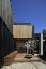 The timber batten ceiling in the living and dining area extends out over the timber deck and seamlessly folds up into the balustrade of the second-floor balcony. “I tried to use windows as transition elements between materials, such as the bifold glazing from the dining area to the outside that separates the different wall materials abutting it, but with the ceiling finish extending beyond,” says architect Kirsten Johnstone. “There’s an element of playfulness with the details.”