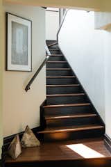 New wood stairs were installed and stained dark brown to contrast against crisp white walls. A custom iron handrail was made to follow the curve of the stairway.